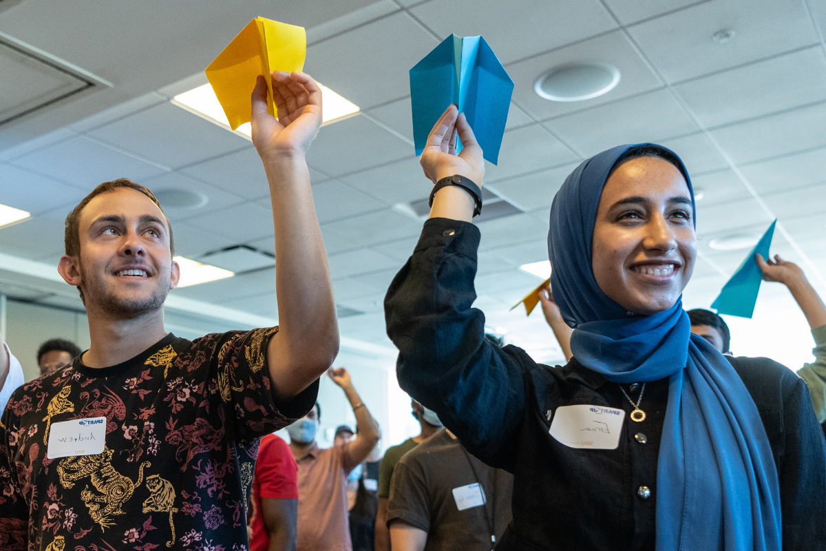 Students throwing paper airplanes.